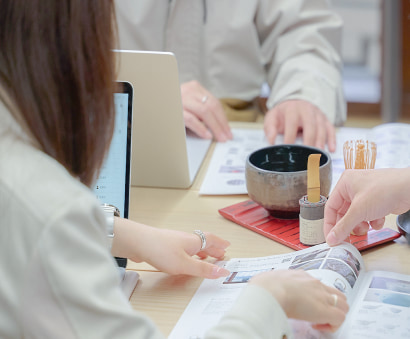 市場データやSNSトレンドをもとに売れる商品設計を検討し、企画立案を行う女性社員の会議風景